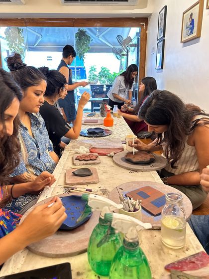 A group of creatives completely in the zone during a weekend workshop at Method Bandra. Everyone is working on their own unique plaques and plates.