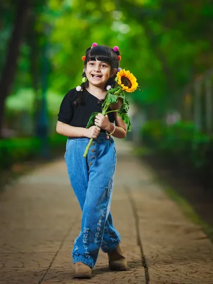 A confident and happy stride down the park path, holding a bright sunflower.