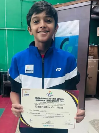 Aadiraj Shetty proudly holding his participation certificate from the Yonex Sunrise Mini National Badminton Championship, representing Maharashtra State.