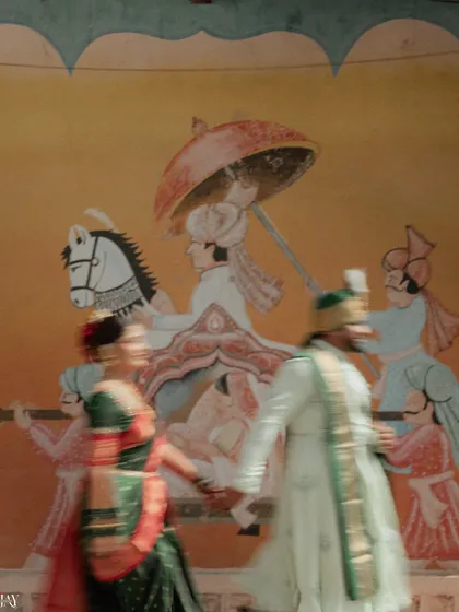 An artistic motion blur shot of the couple dancing in front of the traditional mural. This creative technique captures the energy and joy of the moment, adding a dynamic and modern twist to a traditional shoot.