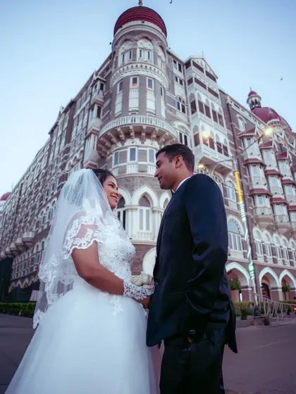 An impressive shot of a couple posing in front of the Taj Mahal Palace Hotel, a grand and iconic pre-wedding photo.