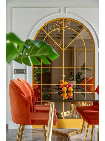 A closer look at the dining setup, where the vibrant chairs contrast beautifully with the sleek, dark tabletop and the reflective quality of the large mirror.