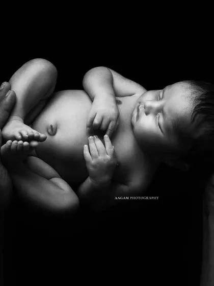 "Capturing these Moments for Eternity." This minimalist shot of a newborn held in strong hands is a powerful symbol of protection and love.