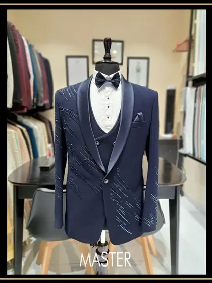 For the groom who wants to make a statement. This navy blue three-piece tuxedo features a unique shawl lapel and delicate crystal work, designed to make your special day even more memorable.