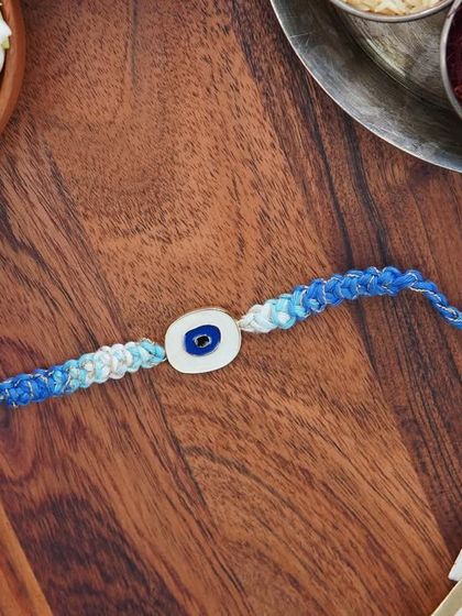 A product shot of the blue Evil Eye Rakhi, showing its vibrant colors.
