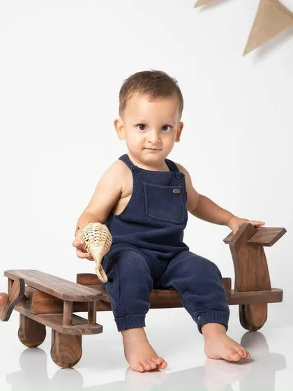 This little boy looks so dapper in his overalls, posing with classic wooden toys for his first birthday pictures.