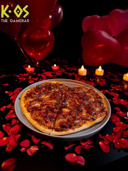 A slice of love. Our Pizza for Lovers is perfect for sharing, set against a romantic backdrop of rose petals.
