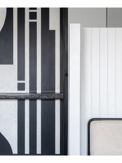 A detail shot from our Powai House project, showcasing the interplay of textures and patterns. The bold, graphic black-and-white design contrasts with the simple, clean lines of the white paneled wall, highlighting our focus on corners and details.