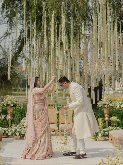 The couple, all smiles, after their Jaimala. The natural light and the elegant white and gold decor create a perfect frame for their happiness.
