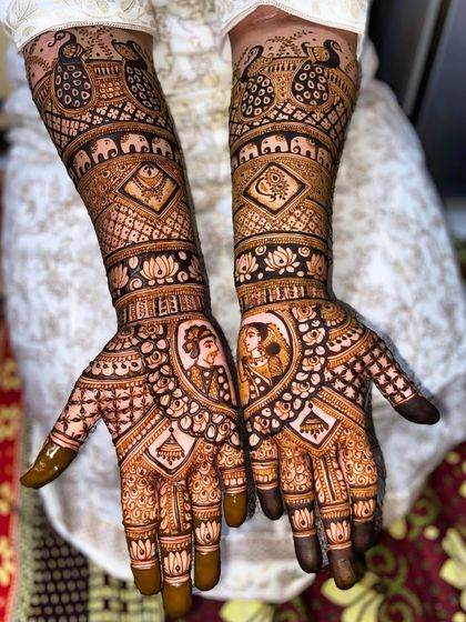 Intricate dulha-dulhan portrait work on the palms. The design is complemented by traditional motifs like elephants and lotuses, creating a rich and complete bridal look.