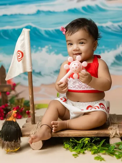 Our little Moana playing with a rattle on her boat, a candid moment captured during our themed session.