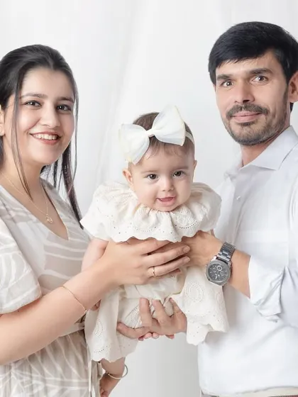 A happy family of three. The baby's smile is just precious in this classic studio portrait.
