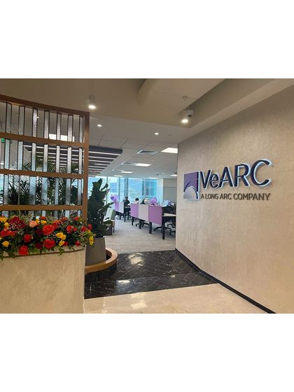 The entrance to the VeArc office, where a floral arrangement and a large potted plant create a welcoming and vibrant first impression.
