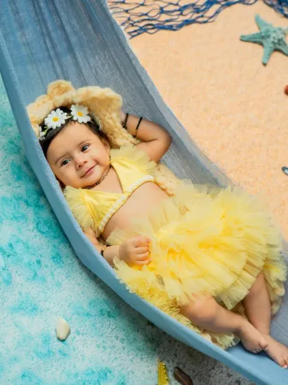 Relaxing in a hammock, this little beachgoer is all smiles. I use props like this miniature hammock and soft, sandy textures to create a variety of poses and compositions within a single theme.