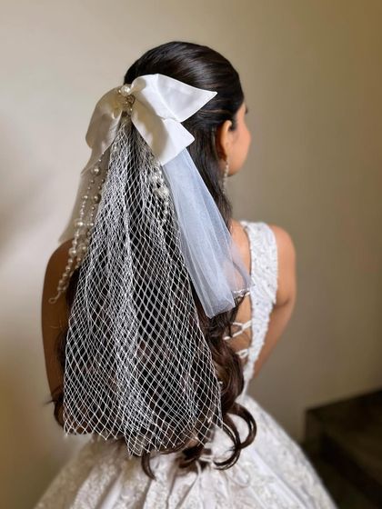 A close-up of the white bow and veil accessory, highlighting its intricate details. It's a perfect statement piece for a fashion-forward bride.