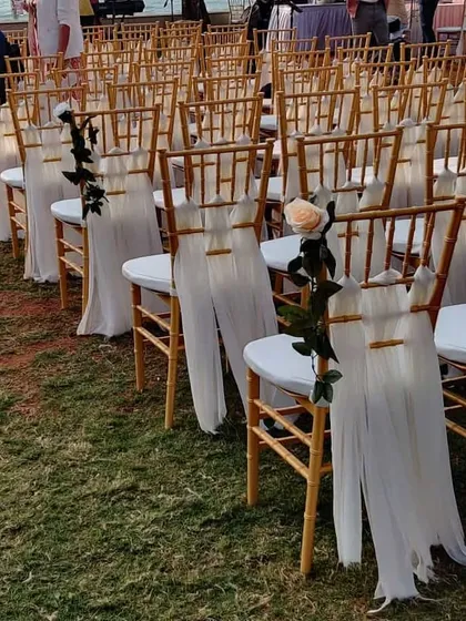 For this outdoor ceremony, we decorated the guest chairs with flowing white drapes and a single, elegant rose. This simple touch adds a layer of sophistication to the seating arrangement.