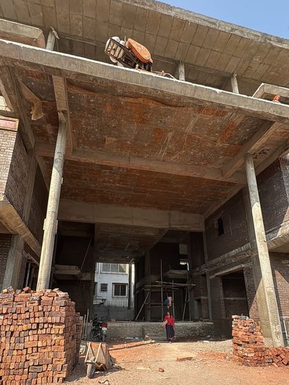 The exterior of a building under construction, with brickwork and concrete framing the future spaces. This image captures the raw potential before the classical facade is applied.