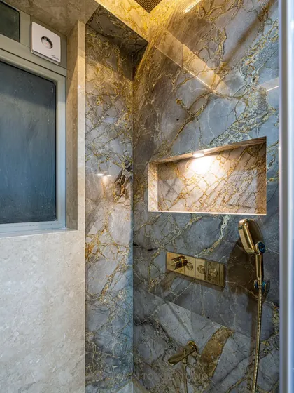 The shower niche, clad in the same beautiful marble as the walls, provides a seamless and practical storage solution.
