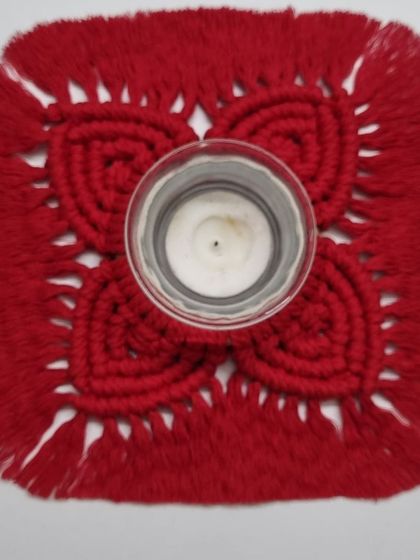 A top-down view of the red diya holder, showing the four heart-shaped petals.