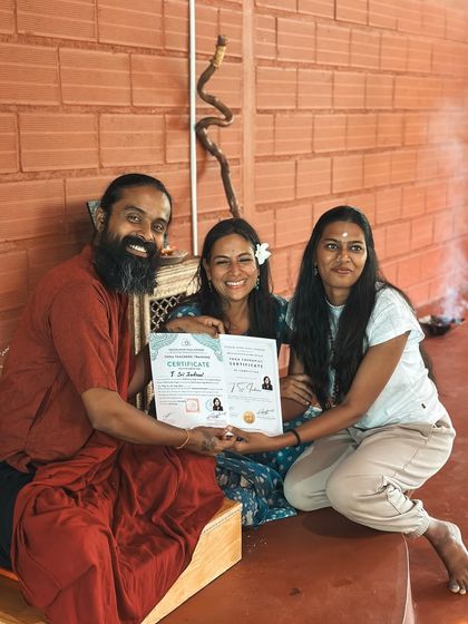 A graduate receives her certificate, her face beaming with joy. This moment marks not an end, but the beginning of a new chapter as a confident and knowledgeable yoga teacher.