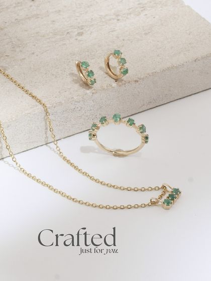The full Petit Emerald trio: a necklace, ring, and huggie earrings. This set proves that small, delicate pieces can make a major impact.
