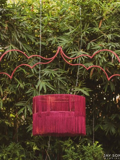A unique hanging lantern made of red thread, adding a pop of color and a touch of modern craft to the "Red Affair" decor.