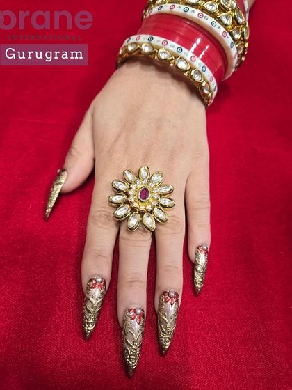 A luxurious set of Karwa Chauth nails with red and gold hand painted chrome work. This is a perfect example of creating custom nails for a traditional Indian festival.