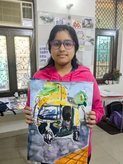 A great example of capturing a local scene. This student proudly holds her watercolor painting of a yellow and green auto-rickshaw.
