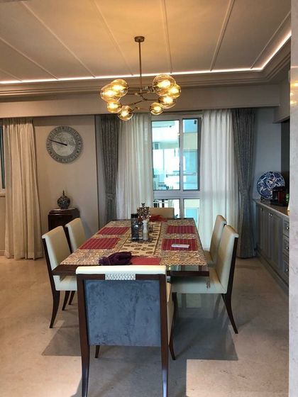 The dining area is defined by a modern chandelier that provides warm, ambient lighting. We selected a timeless dining set and used subtle ceiling details with integrated lighting to create a refined atmosphere for meals.