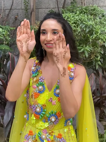 A happy portrait of the bride, showcasing her radiant smile and the fresh, festive makeup perfect for a mehendi day.