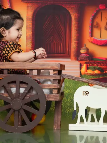 A side view of the baby in the farm cart, interacting with the props. This shot captures the playful and exploratory nature of a child.
