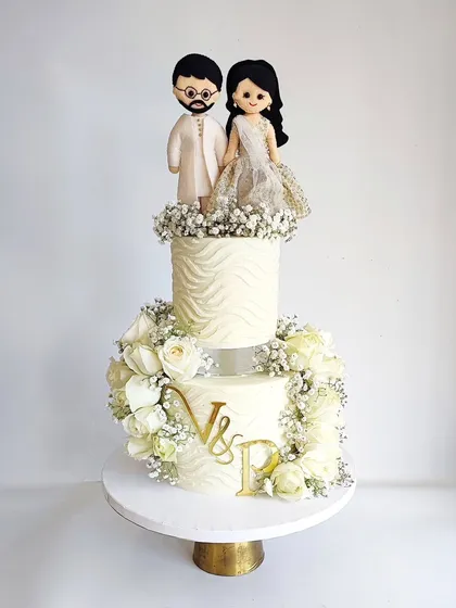 A similar design featuring a custom couple topper and beautiful white roses. This style is incredibly versatile for any romantic celebration.