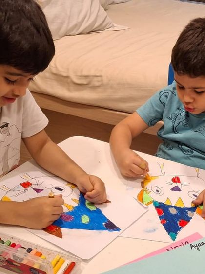 Two brothers work side-by-side, each creating their own version of the class project. Our sessions encourage individual creativity in a shared, supportive environment.