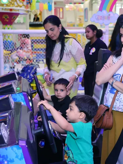 Fun for the whole family is what I aim for. Here are parents helping their little ones with the racing games during a Candyland-themed party.