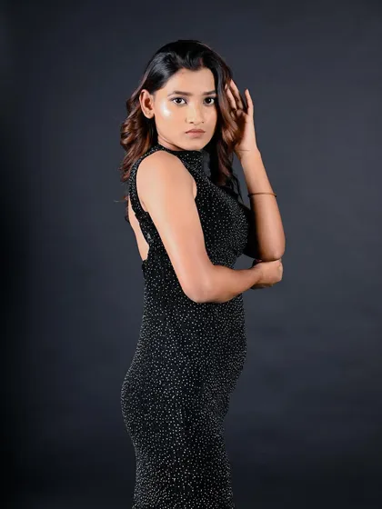 A profile shot that showcases the backless design of the dress and the model's elegant posture.