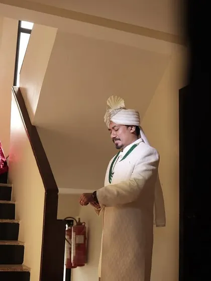 The groom waiting at the bottom of the stairs for his bride's descent. A shot filled with anticipation and romance.