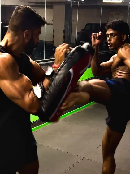 A perfect display of power and technique. One of our fighters executes a powerful kick during a pad work session, demonstrating the precision and force we cultivate in our striking classes.