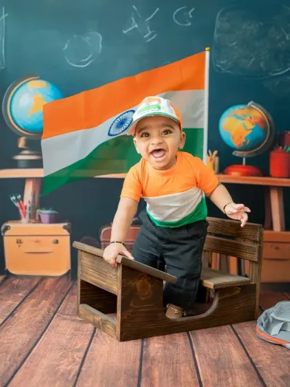 This toddler is excitedly climbing onto the school desk, adding a sense of action and fun to the Republic Day photoshoot.