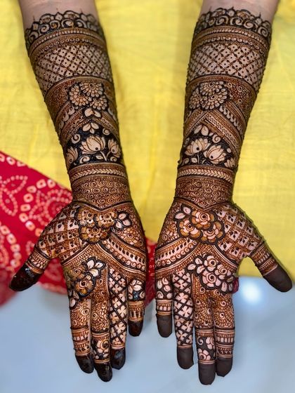 A gorgeous full-hand design with a mix of floral motifs and traditional check patterns, set against a bright yellow background.