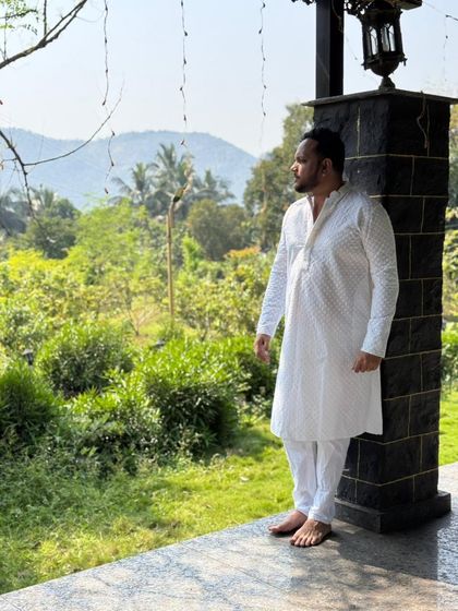 A side profile of the white chikankari kurta, showing the fine embroidery. This timeless piece offers a clean and sophisticated look for any man.