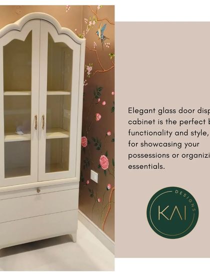 A classic glass-door display cabinet in a soft white finish. With its elegant curved top and ample shelving, it's the perfect piece for showcasing treasured possessions or organizing essentials in a dining or living room.