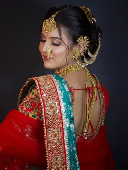 A back profile showing the beautiful blouse design and the neat finish of the bridal bun and saree draping.