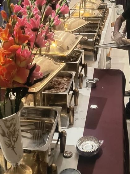 Guests enjoying the food at one of our indoor events. This shot captures a moment of service, with our staff ensuring the buffet is always well-stocked and tidy.