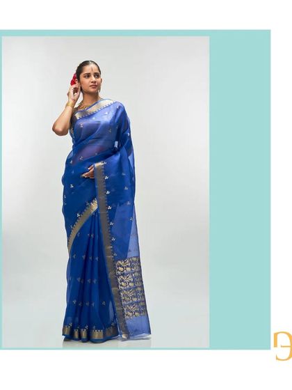 A full view of the cerulean blue saree, its body dotted with delicate zari buttis that shimmer in the light.