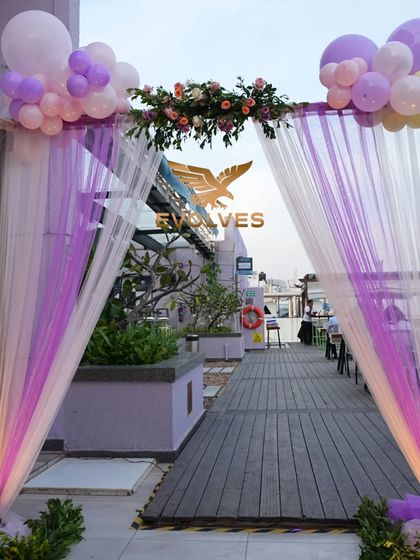 The entrance decor for the butterfly-themed party, featuring a beautiful arch with drapes, balloons, and floral arrangements, setting a magical tone from the moment guests arrive.