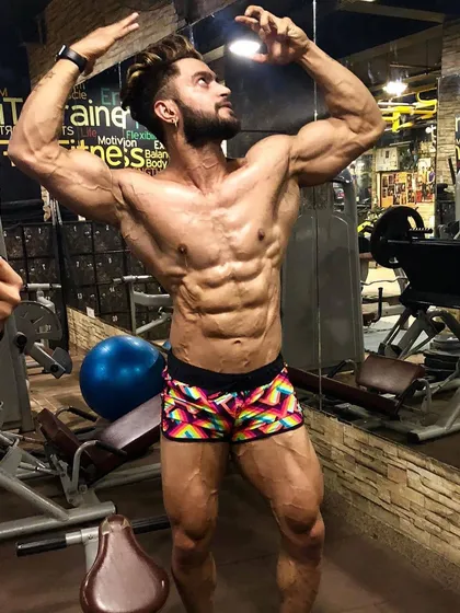 A complete physique requires dedication to every muscle group. This classic front double bicep pose shows the level of conditioning and muscle maturity needed for competitive bodybuilding, from shredded abs to well-developed quads.