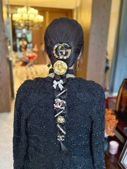 A detailed close-up of the accessory-laden braid, showing how to layer different clips for a maximalist and stylish effect.