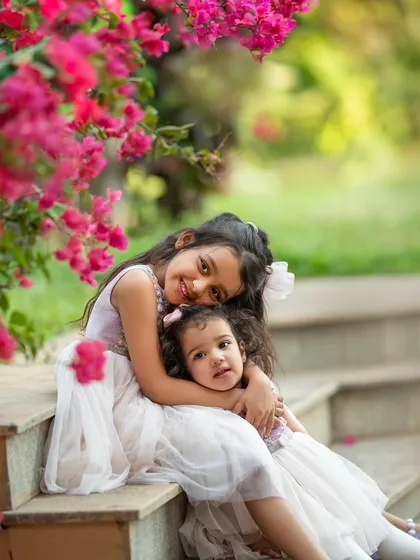 There is nothing sweeter than the bond between sisters. I always encourage siblings to join in, because these are the moments that truly tell your family's story. Capturing this hug under the bougainvillea was just perfect.