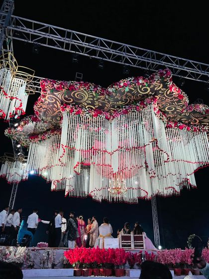The wedding ceremony taking place under our custom-designed, massive hanging floral installation. This shows how our decor becomes the centerpiece of the entire event.