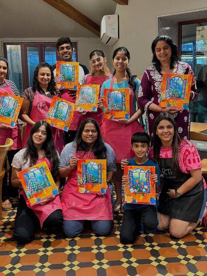 A family group, including a young boy, showing off their window paintings. It's a perfect activity for a family weekend outing.